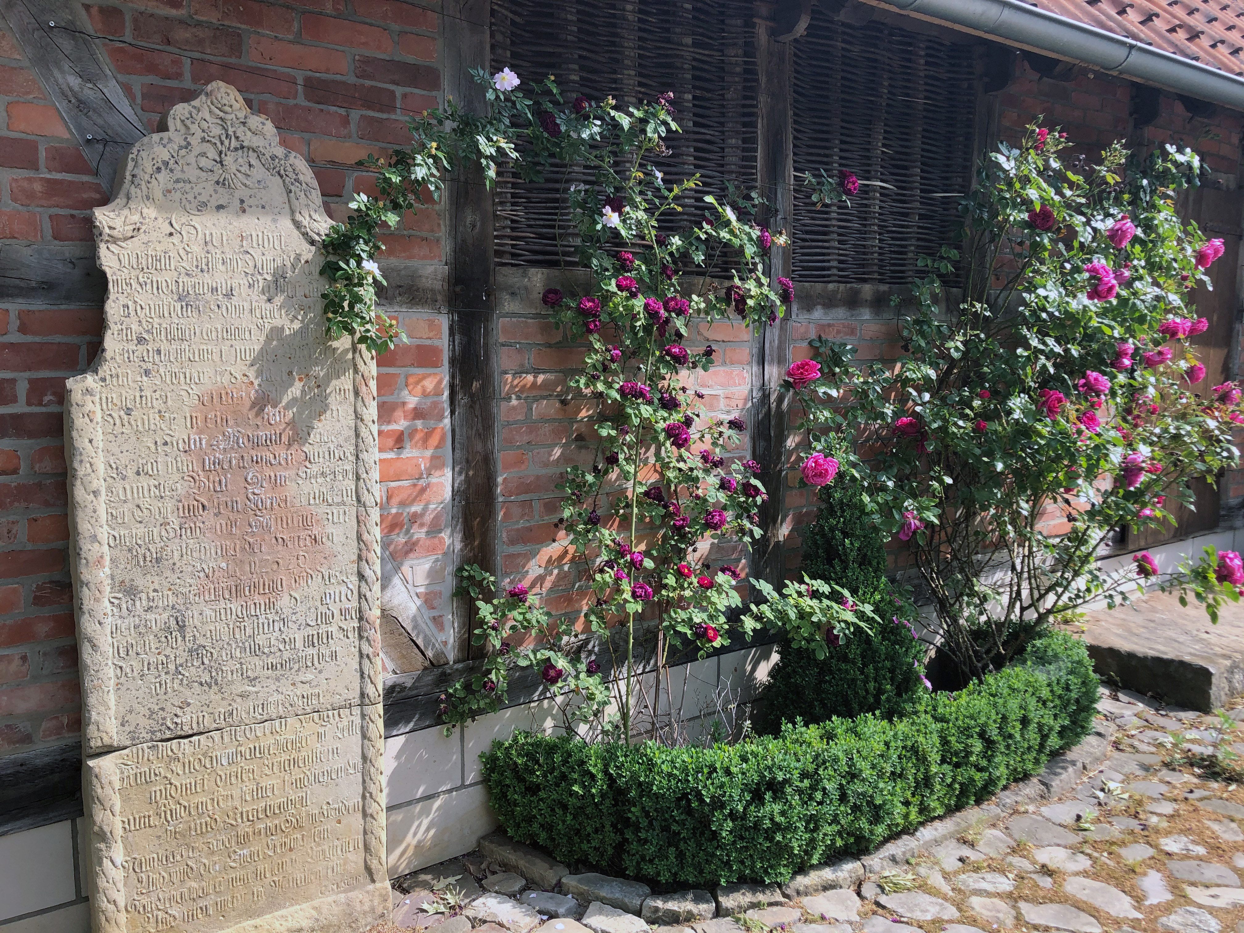 Sandsteinplatte mit Inschrift an der Wand eines Fachwerkhauses